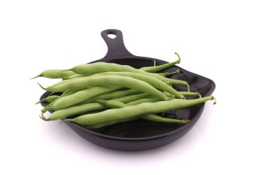 Pişirme tavasındaki bir avuç yeşil fasulye beyaz arka planda izole edilmiş. Sağlıklı, besleyici vejetaryen yiyecekler.