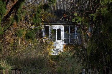 Neredeyse yabani bitkiler, otlar ve ağaçlar tarafından yutulan eski bir beyaz ev. Gözlerden uzak konutlar gizem ve çürümeyi çağrıştırıyor. Doğa yavaş yavaş mekanı geri alırken, sessiz bir terk edilme havası var..