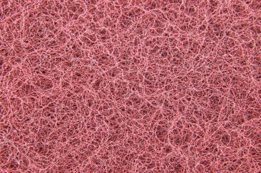 Pembe bir temizlik yastığının ayrıntılı görüntüsü pürüzlü, lifli ve dokulu yüzeyini ortaya çıkarıyor. Arkaplanlarını temizlemek için mükemmel.