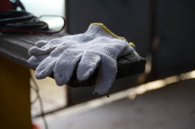 Bir çift kullanılmış pamuk iş eldiveninin yakın çekimi sarı bukle ile, kaba ahşap bir yüzeye yerleştirilmiş doğal ışık altında