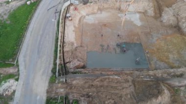 İnşaat alanına beton döken hava manzaralı inşaat işçileri.