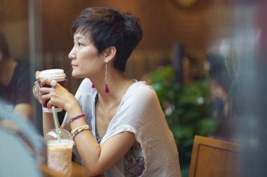 bir kafede oturan genç bayan