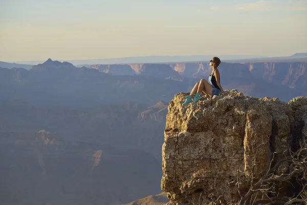 genç kadını uçurum üzerinde Grand Canyon hiking sonra dinlenme