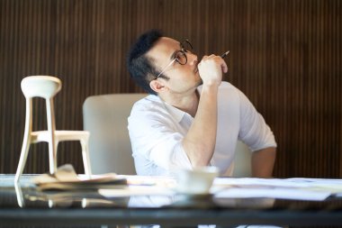 Masada çalışırken günlük kıyafet tasarlayan Asyalı tasarımcı