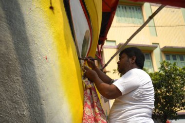 14th October 2023, Kumartuli, Kolkata, West Bengal, India. Man in White Painting Eye of the Gigantic Durga Idol Under Scaffolding