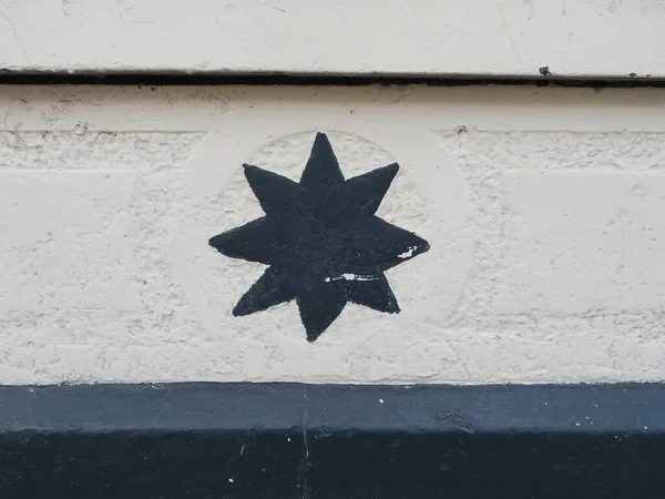 Una Estrella Pintada Negro Con Ocho Picos Una Pared Blanca — Foto de Stock