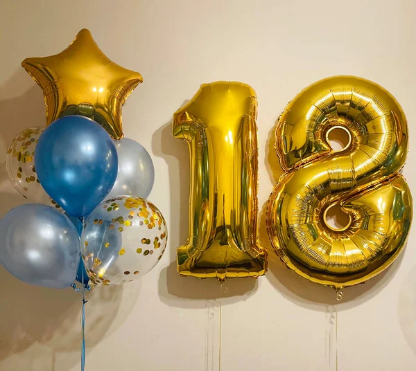 Composition of air helium balloons blue mother-of-pearl, transparent with confetti, gold stars and a large gold number eighteen