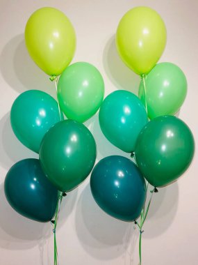 Sarı renkli helyum balonları ve yeşilin farklı tonlarında parlak bir bileşim.