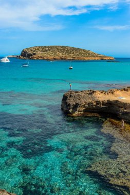 Cala Conta, İbiza, İspanya - 18 Ağustos 2014: İbiza adasındaki en bilinen plaj. Cala Conta, kıyı şeridi, kumlu alanlar ve kayalık bölgeler boyunca farklı girişleri olan doğal bir cennettir..
