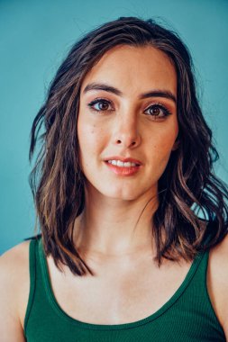 Güzel bir ifadeyle kameraya bakan bir kadın.