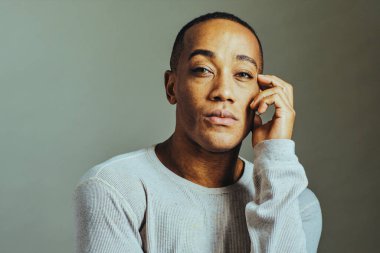 Yüzüne dokunan düşünceli bir adam.