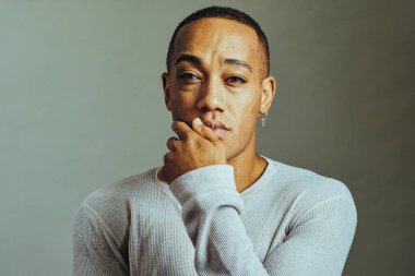 Eli çenesinde, ağzı kapalı ciddi düşünen bir adam.