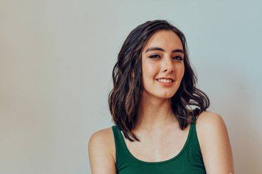 Gülümseyen genç yetişkin kameraya yakından bakıyor.