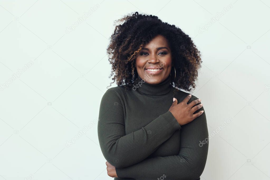 Portrait of beautiful smiling woman wearing green sweater against white background