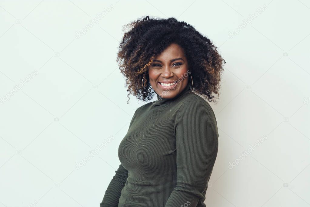 Cheerful woman with frizzy hairstyle against white background. Smiling