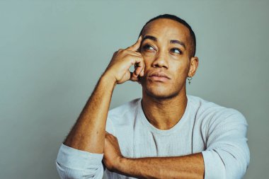 Eli şakakta olan düşünceli bir adam kollarını kavuşturup stüdyoyu kapatıyor.