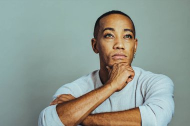 Eli çenesinde düşünceli bir adam kollarını kavuşturup stüdyoyu kapatıyor.