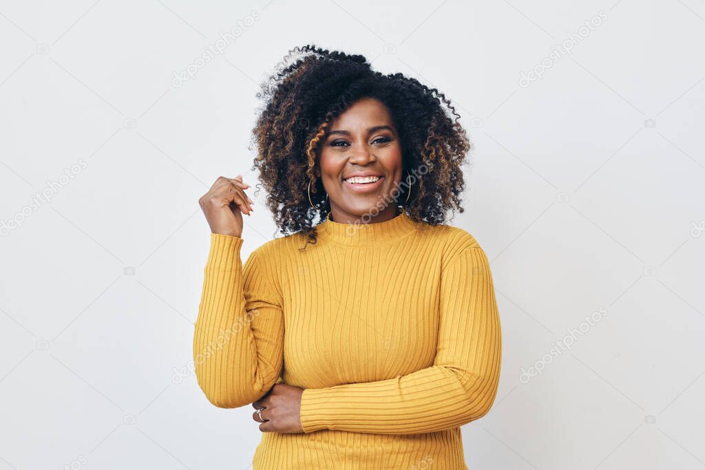 Portrait of smiling beautiful Afro woman standing against white background looking at camera