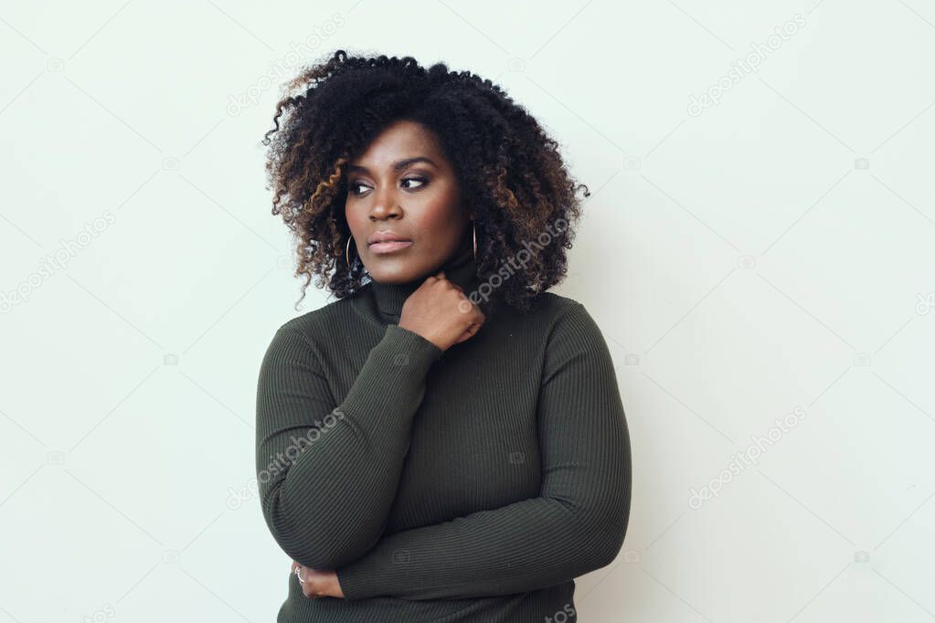 Thoughtful mid adult Afro woman looking away against white background