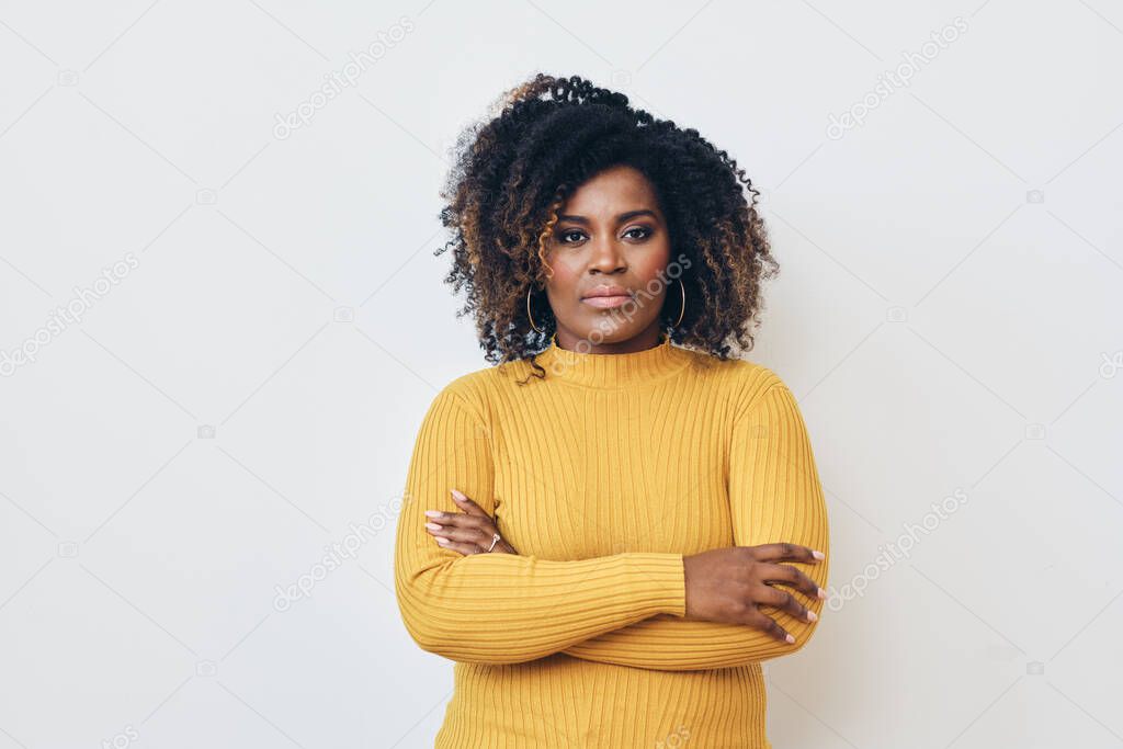 Portrait of serious beautiful Afro woman standing with arms crossed