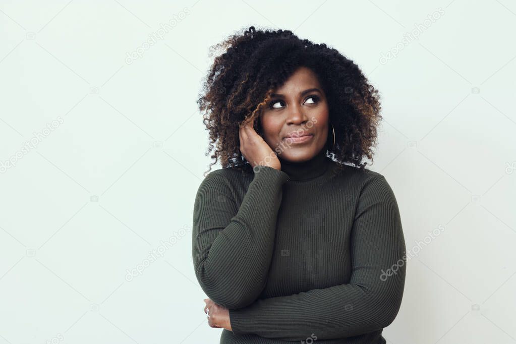 Thoughtful mid adult Afro woman looking away against white background