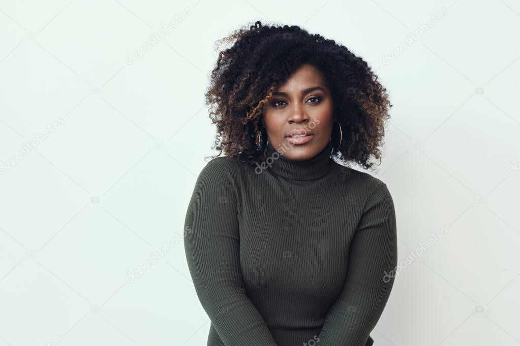 Thoughtful mid adult Afro woman looking at camera white background