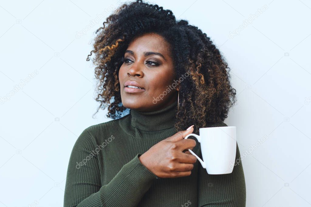 Cheerful woman enjoying while looking away with coffee cup against white background