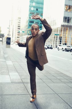 Modern şehir arka planında poz veren yakışıklı Afro-Amerikan adam.