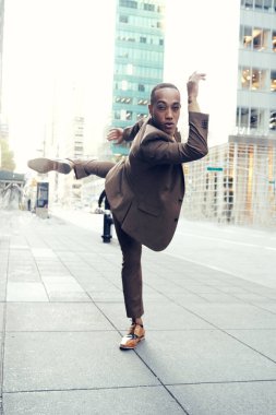 Modern şehir arka planında poz veren yakışıklı Afro-Amerikan adam.