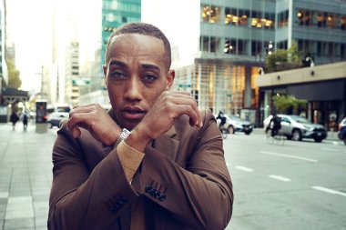 Modern şehir arka planında poz veren yakışıklı Afro-Amerikan adam.