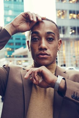 Modern şehir arka planında poz veren yakışıklı Afro-Amerikan adam.