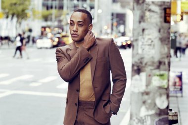 Modern şehir arka planında poz veren yakışıklı Afro-Amerikan adam.