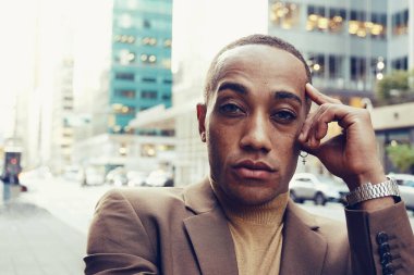 Modern şehir arka planında poz veren yakışıklı Afro-Amerikan adam.