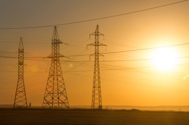 Yüksek gerilim enerji nakil hattı. Enerji ayağı. Gün batımında,