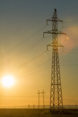 Yüksek gerilim enerji nakil hattı. Enerji ayağı. Gün batımında,