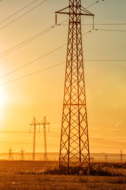 Yüksek gerilim enerji nakil hattı. Enerji ayağı. Gün batımında,