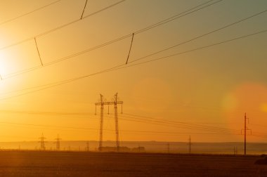 Yüksek gerilim enerji nakil hattı. Enerji ayağı. Gün batımında,