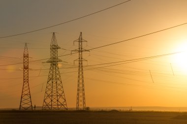 Yüksek gerilim enerji nakil hattı. Enerji ayağı. Gün batımında,
