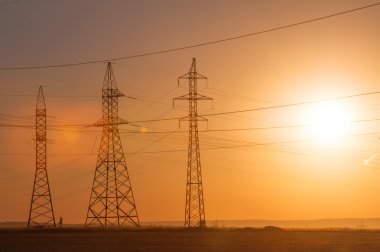 Yüksek gerilim enerji nakil hattı. Enerji ayağı. Gün batımı, şafakta. Elektrik