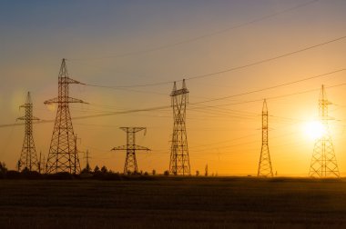 Yüksek gerilim enerji nakil hattı. Enerji ayağı. Gün batımı, şafakta. Elektrik