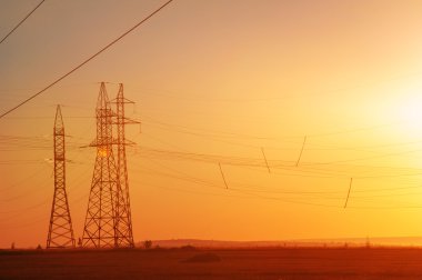 Yüksek gerilim enerji nakil hattı. Enerji ayağı. Gün batımı, şafakta. Elektrik