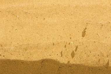 Doku, arka plan. kum plaj. gevşek taneli madde, soluk sarımsı kahverengi, silisli ve diğer kayalar erozyon kaynaklanan ve plajları büyük bir kurucu şekillendirme,