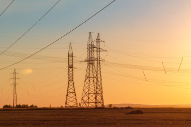 Yüksek gerilim enerji nakil hattı. Enerji ayağı. Gün batımı, şafakta. Elektrik