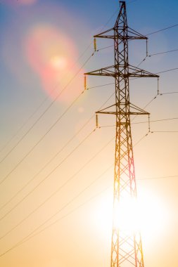 Yüksek gerilim enerji nakil hattı. Enerji ayağı. Gün batımı, şafakta. Elektrik
