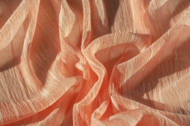 İpek kumaş. Kahverengi kırışık kumaş dokusu. Kahverengi buruşuk, dalgalı yüzey dokusu. Yakın çekim, yumuşak odaklanma. arkaplan, kalıp