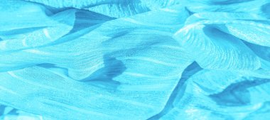 İpek kumaş. Mavi buruşuk kumaş dokusu. Mavi buruşuk, dalgalı yüzey dokusu. Yakın çekim, yumuşak odaklanma. arkaplan, kalıp