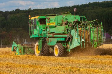 Arpa hasadının yaz fotoğrafı olan Combine Harvester, ekinleri hasat etme, harman etme ve sarma sürecini birleştiren mekanize bir yöntemdir. 
