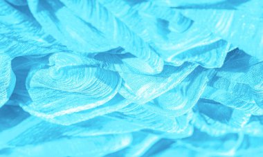 İpek kumaş. Mavi buruşuk kumaş dokusu. Mavi buruşuk, dalgalı yüzey dokusu. Yakın çekim, yumuşak odaklanma. arkaplan, kalıp