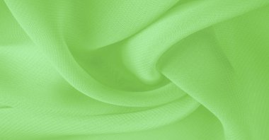 Doku. şablon. Açık yeşil ipek polyester. Kireç yeşili ipek kumaştan. Şeffaf arkaplan ve elbise dikmek için açık kumaştan yapılmış. Tekstil panoraması