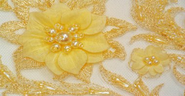 Dantel sarıdır. Doku. Geçmişi. şablon. Bu, altın işlemeli dantel kumaşa dikilmiş yüksek kaliteli sarı işlemeli bir nakış. kartpostal, poster, doku veya duvar kağıdı için kullan